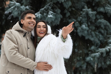 Poster - Loving couple in park on snowy winter day