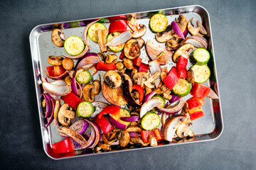 Wall Mural - Overhead View of Raw Vegetables Seasoned with Olive Oil and Spices: Sliced and seasoned mushrooms, zucchini, bell peppers, onions, vegetables on a sheet pan 