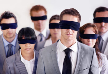 Staff training is paramount to a capable team. Shot of a group of businesspeople all wearing blinfolds.