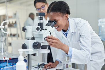 Wall Mural - science allows you to see a lot more. shot of a young scientist using a microscope in a lab.