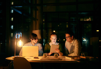 Leinwandbilder - They never fail to meet the deadline. Shot of businesspeople working together on a digital tablet in an office at night.