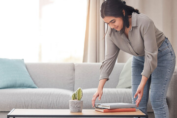 Wall Mural - Lets do some cleaning up. Shot of a young woman cleaning her lounge at home.