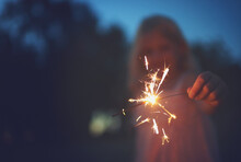 Sparkles Are Cool. Shot Of A Unrecognizable Little Girl Playing With A Sparkler At Night Time Outside In Nature.