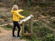 © Click98 - A woman checks an information panel and points the way. Tourist information on an information panel