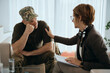 Depressed veteran listens to his supportive counselor during therapy session at mental health center.