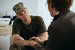 © Drazen - Sad military man talks to mental health professional while holding hands with her during counseling.
