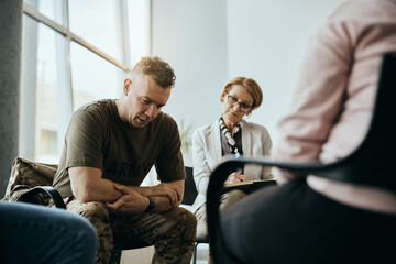 Wall Mural - Depressed military man talks during group therapy meeting at mental health center.