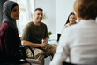 © Drazen - Happy soldier and group of people having group therapy at mental healthcare center.