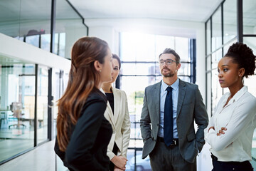 Poster - At a crossroads in business. Cropped shot of a group of businesspeople having a serious discussion in the office.