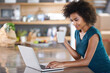 © Mapodile M./peopleimages.com - Having coffee with a friend. Young woman using a laptop while drinking from a mug.