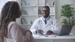 © Synthex - Smiling doctor obstetrician conducting health check-up of pregnant black woman