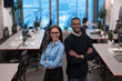 © .shock - Two happy diverse professional executive business team people woman and African American man looking at camera standing in office lobby hall. Multicultural company managers team portrait.