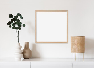 Blank picture frame mockup on white wall. White living room design. View of modern scandinavian style interior with artwork mock up on wall. Home staging and minimalism concept