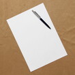 © Stanislav - Template of white paper with pen lies diagonally on light brown cloth background. Concept of business plan and strategy. Stock photo with empty space for text and design.