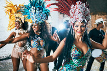 We Are Here To Entertain You. Cropped Shot Of Beautiful Samba Dancers Performing In A Carnival With Their Band.