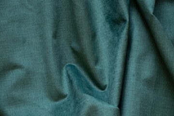 Wall Mural - Dark green wrinkled fabric as a background close-up, fashion and trends, green