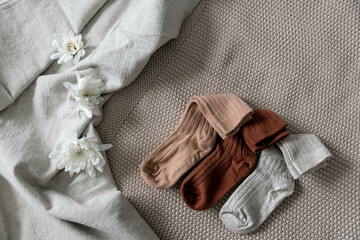 Children's socks are laid out on a linen bedspread. Photo content for a baby store. 