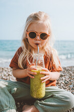 Toddler Girl Drinking Organic Smoothie Reusable Glass Bottle Child Vegan Food Healthy Lifestyle Summer Vacations Breakfast On Beach