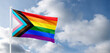 Progress LGBTQ rainbow flag waving in the wind at cloudy sky. Freedom and love concept. Pride month. activism, community and freedom Concept. Copy space