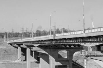  A road bridge over the river. Structures of the automobile bridge from below. Black and white photo