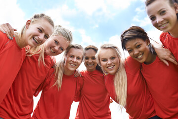 We are ready to win. Portrait of an all-girls soccer team standing arm in arm outside.