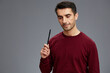 © SHOTPRIME STUDIO - portrait man posing with pen gesture hands red sweater Gray background