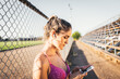 © padnob - Beautiful caucasian young active woman setting a music playlist on her smartphone before start running.