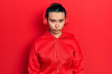 Sticker - Beautiful hispanic woman with short hair listening to music using headphones skeptic and nervous, frowning upset because of problem. negative person.