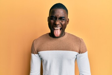 Young african american man wearing casual clothes sticking tongue out happy with funny expression. emotion concept.