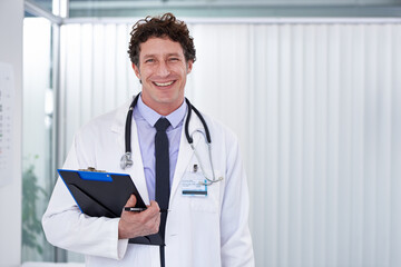 Poster - Changing lives one day at a time. Cropped shot of a handsome doctor smiling happily at the camera.