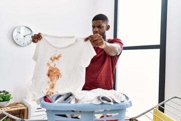 Sticker - Young african american man holding dirty clothes at laundry room