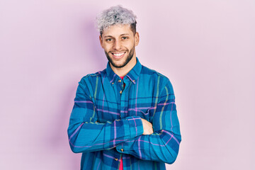 Wall Mural - Young hispanic man with modern dyed hair wearing casual retro shirt happy face smiling with crossed arms looking at the camera. positive person.