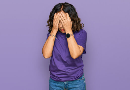 middle age hispanic woman wearing casual clothes with sad expression covering face with hands while 