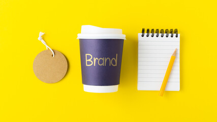 Wall Mural - coffee brand identity concept with brand word on coffee cup with tag label and notebook, mockup