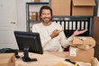 © Krakenimages.com - Handsome middle age man working at small business ecommerce amazed and smiling to the camera while presenting with hand and pointing with finger.
