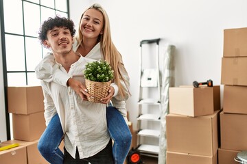 Poster - Young man holding woman in his back at new home.