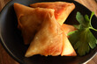 Chicken samosas in a bowl. Traditional samoosas. Cape Malay cooking. Starter or appetizers deep fried and made with pastry with various fillings including beef mince, steak, chicken, potato, cheese