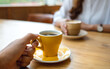 © Farknot Architect - Closeup image of a young couple holding and drinking coffee together in cafe
