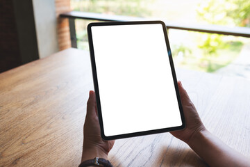 Mockup image of a woman holding digital tablet with blank white desktop screen