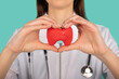 Female doctor with a stethoscope is holding mockup thyroid gland. Help and care concept