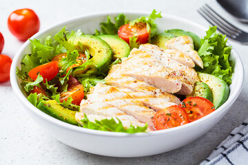 Grilled chicken breast salad with avocado and cherry tomatoes. Healthy diet food concept.