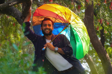 man with umbrella in spring season with flowers in background