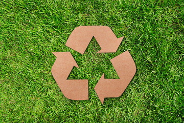 recycling symbol color .recycled brown paper on green.lawn