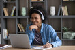 © fizkes - Happy satisfied African American student girl in wireless headphones making video call to tutor, making notes at laptop, studying online in library, watching learning virtual webinar, lesson, class