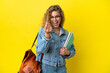 © luismolinero - Young student caucasian woman isolated on yellow background making money gesture