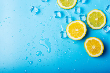 Wall Mural - juicy fresh lemon slices and ice cubes on a blue background. Top view, flat lay