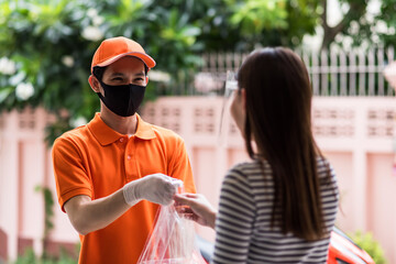 deliveryman in face mask give food to young female customer