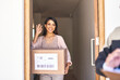 © Nikish H/peopleimages.com - Our service will always leave you smiling. Shot of a young woman waving goodbye to a delivery man.