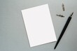 © IndrePau - Blank paper sheet, card mockup, page for lettering mockup, calligraphy pen and nibs, flat lay composition on gray background.