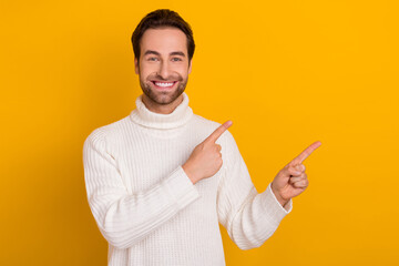 Wall Mural - Photo of cheerful nice glad bearded guy direct finger empty space wear white sweater isolated yellow color background